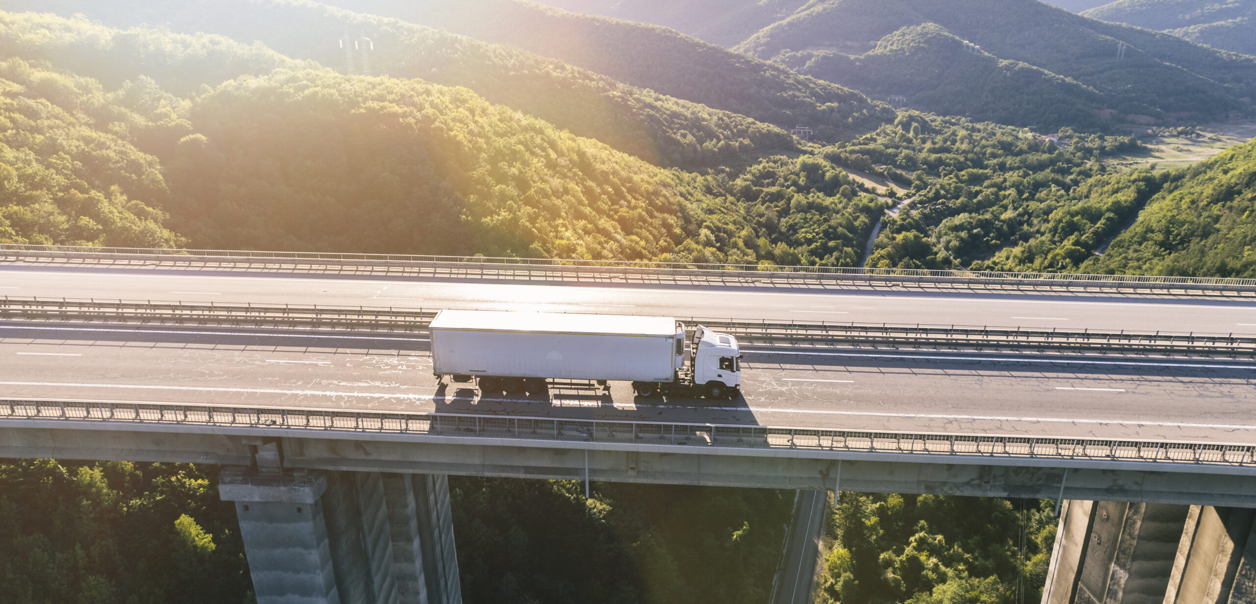 Christchurch Movers truck on highway in mountain at sunset aerial view